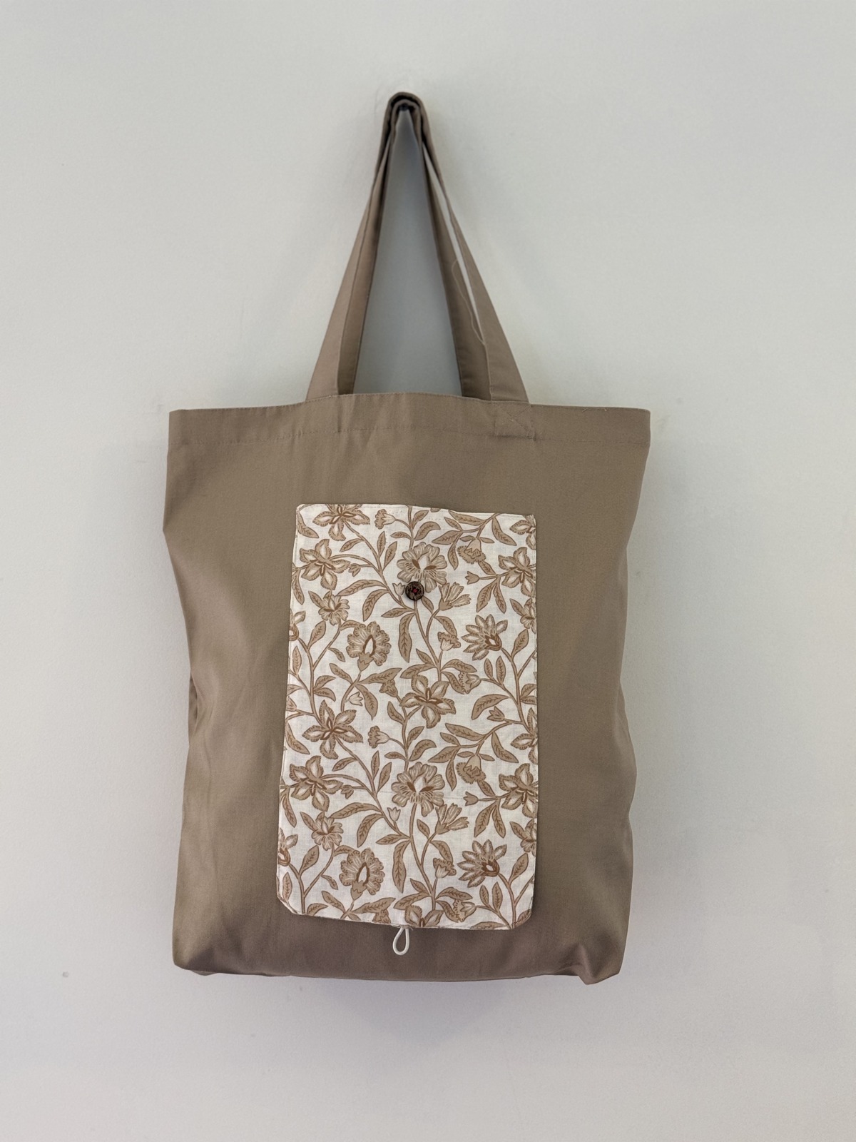 Taupe tote with a botanical floral panel, button and loop